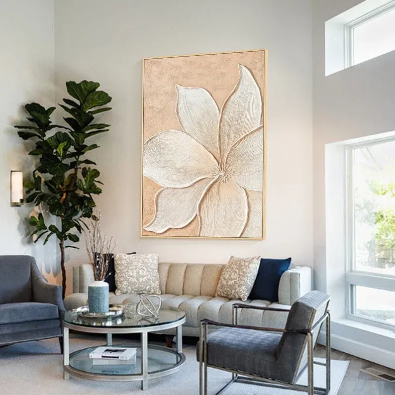 a modern living room with a large floral artwork hanging on the wall, a gray sofa, a glass coffee table, and a gray armchair.