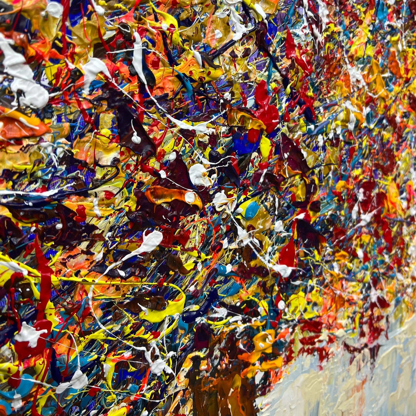 The image is a vibrant and colorful abstract painting, featuring a variety of bold and bright colors such as red, yellow, blue, and orange. The painting appears to be a dynamic and energetic composition, with splashes of color and texture creating a visually striking and captivating scene.