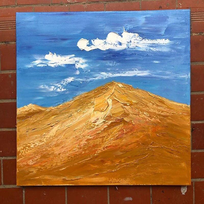 a painting of a mountain on a brick wall
