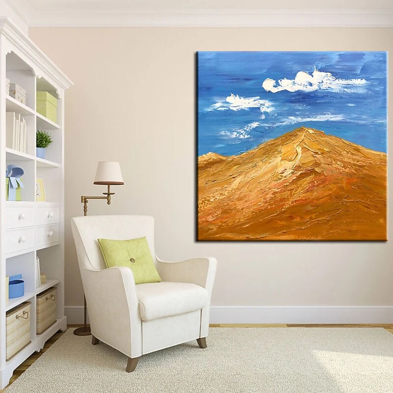 a living room with a chair and a painting on the wall