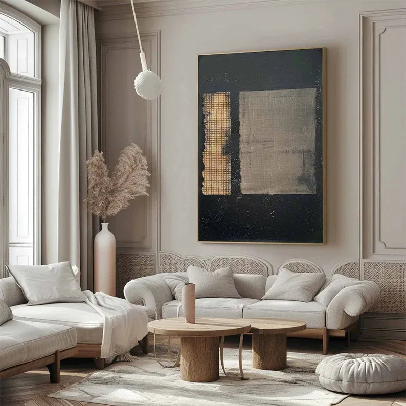 a modern and stylish living room with a large abstract painting on the wall, a sofa, a coffee table, and a large window.