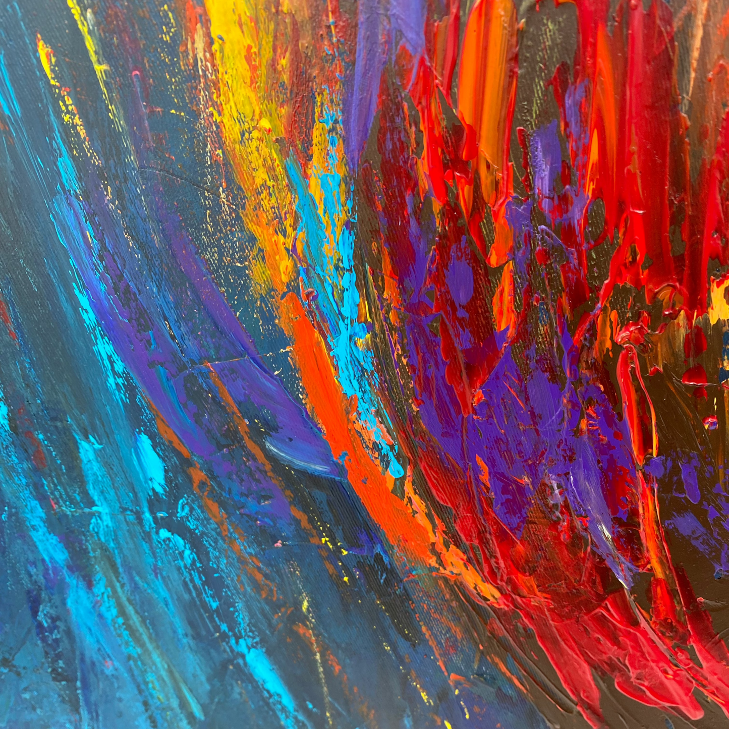 The image is a vibrant abstract painting with bold strokes of red, blue, and yellow. The painting features a dynamic and energetic composition, with the colors and brushstrokes creating a sense of movement and emotion.