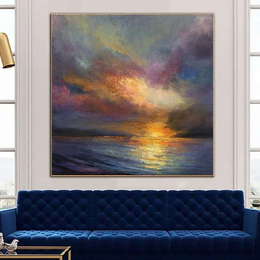 a large, vibrant painting of a sunset over the ocean, hanging on a wall above a blue velvet couch in a living room setting.