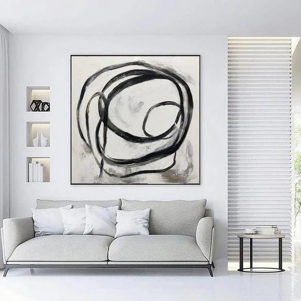 a modern living room with a gray sofa, a large abstract painting on the wall, and a small side table.