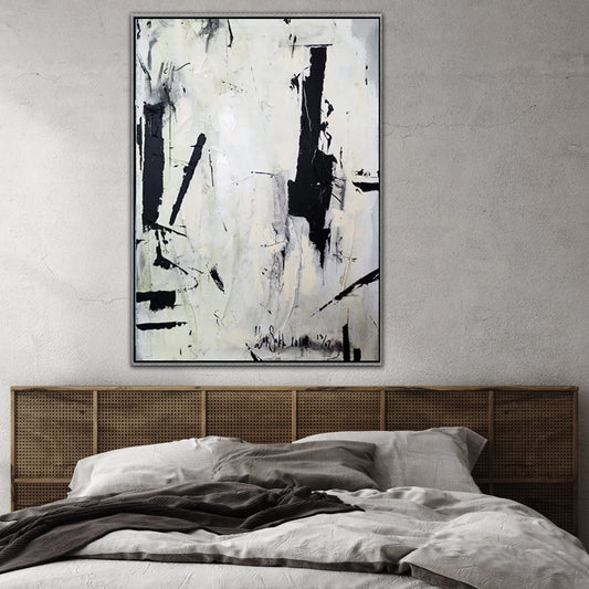 a large abstract painting hanging on a wall above a bed with a wooden headboard.
