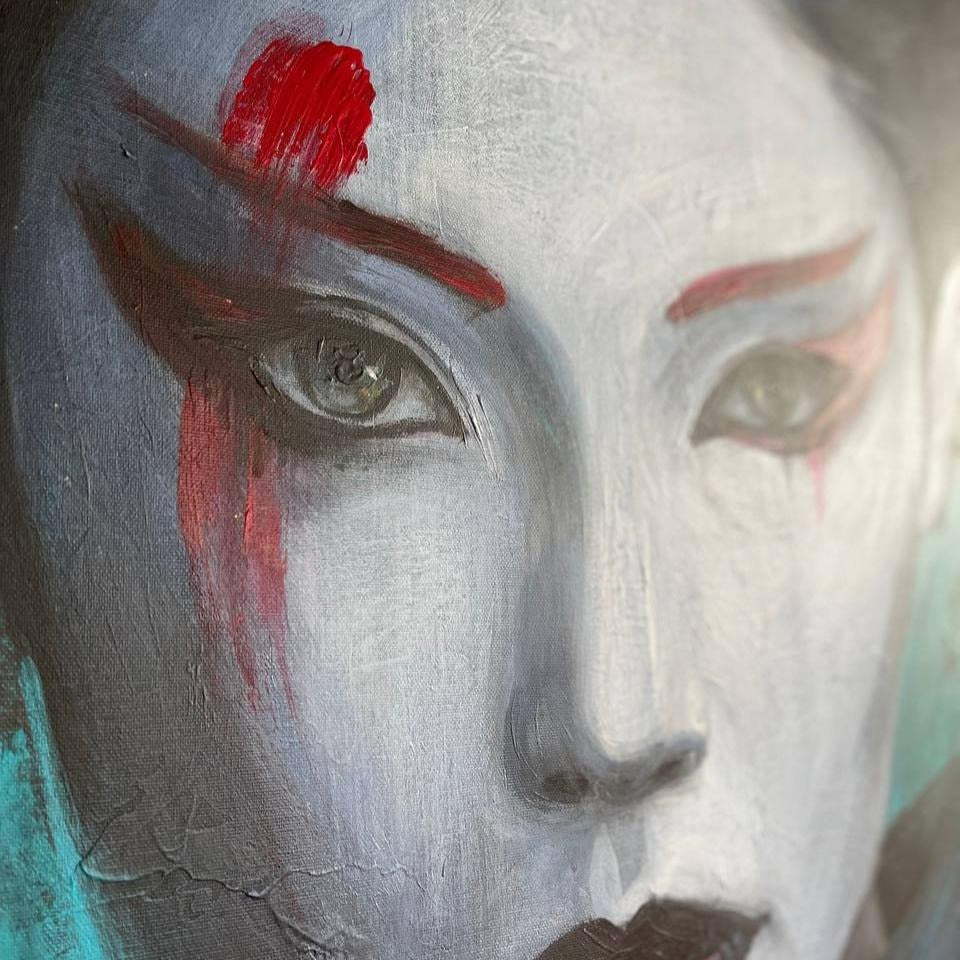 The image is a close-up of a woman's face, with a striking red dot on her eye and dramatic makeup.