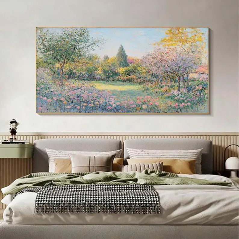 a large painting of a garden hanging above a bed with a gray headboard and white bedding.