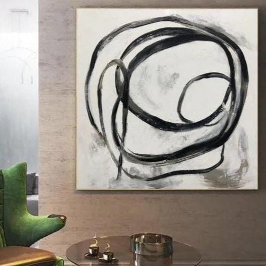 a large abstract painting hanging on a wall, with a glass coffee table in the foreground.