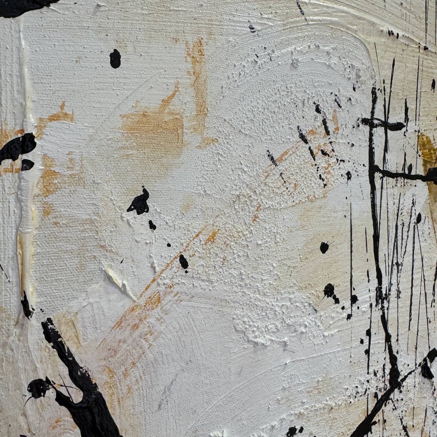 The image is a close-up of a white surface with black splatters and splotches, creating an abstract and textured appearance.