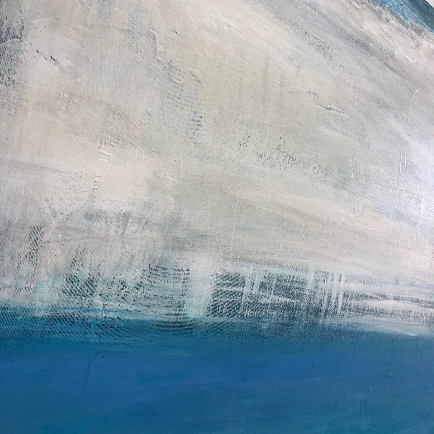 The image is a close-up of a painting that features a blue and white color scheme, with the blue area appearing more prominent than the white area. The painting has a textured, brushstroke-like appearance, giving it a sense of depth and dimension.
