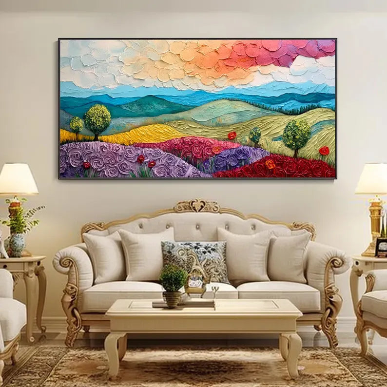 a large, colorful painting of a countryside landscape hanging on a wall above a white sofa in a living room setting.