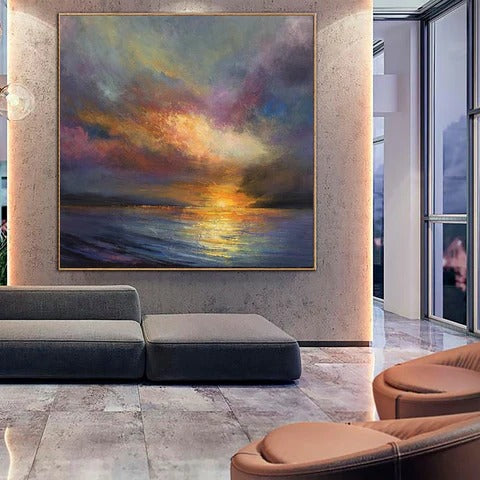a large, colorful painting of a sunset over the ocean, hanging on a wall in a modern living room setting.