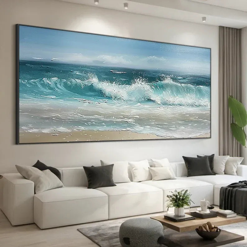 a large, vibrant painting of a beach scene with crashing waves, hanging on the wall above a white sofa in a modern living room setting.