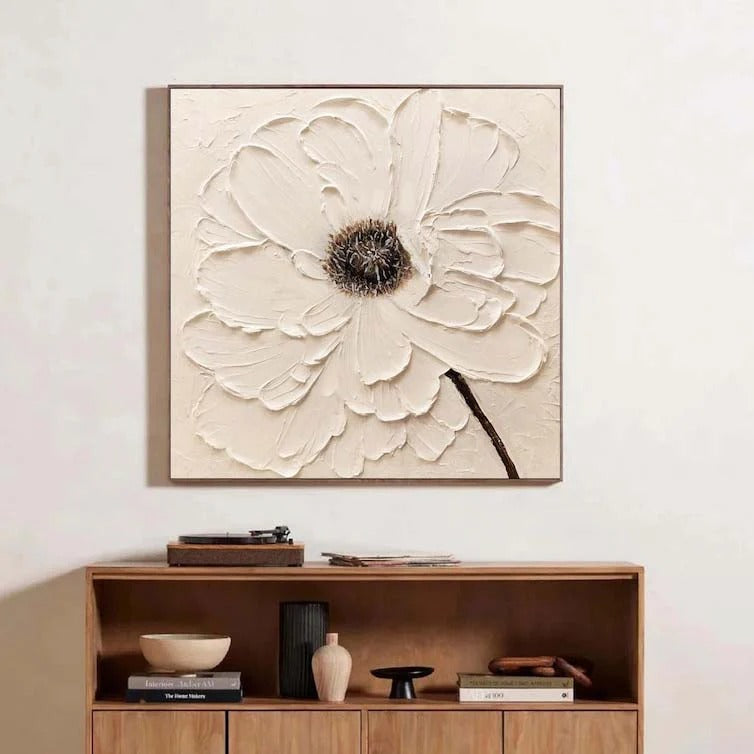 a large, white, flower-like artwork hanging on a wall above a wooden cabinet with various items on its shelves.