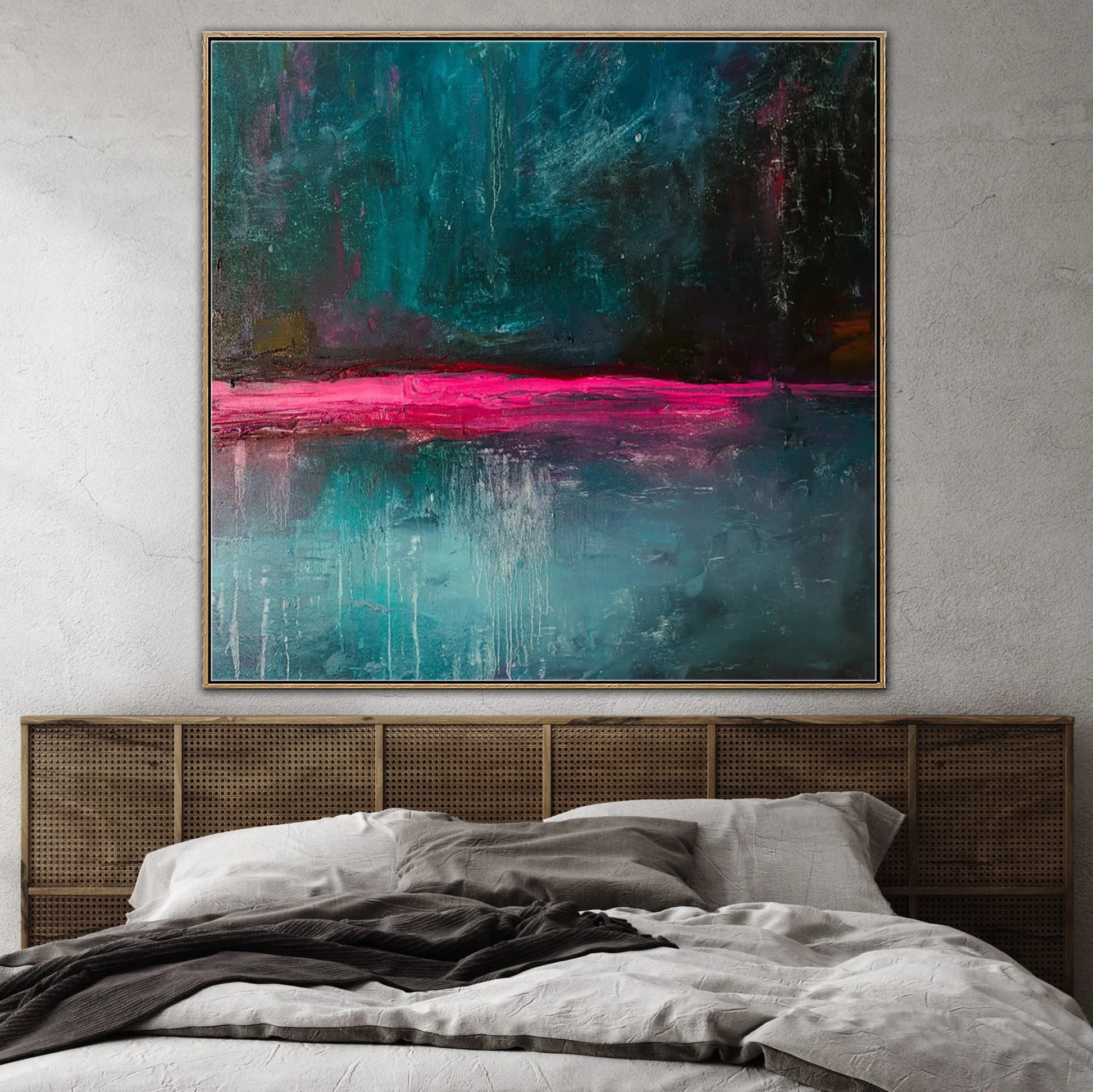 a large abstract painting hanging on a wall above a bed with a wooden headboard.