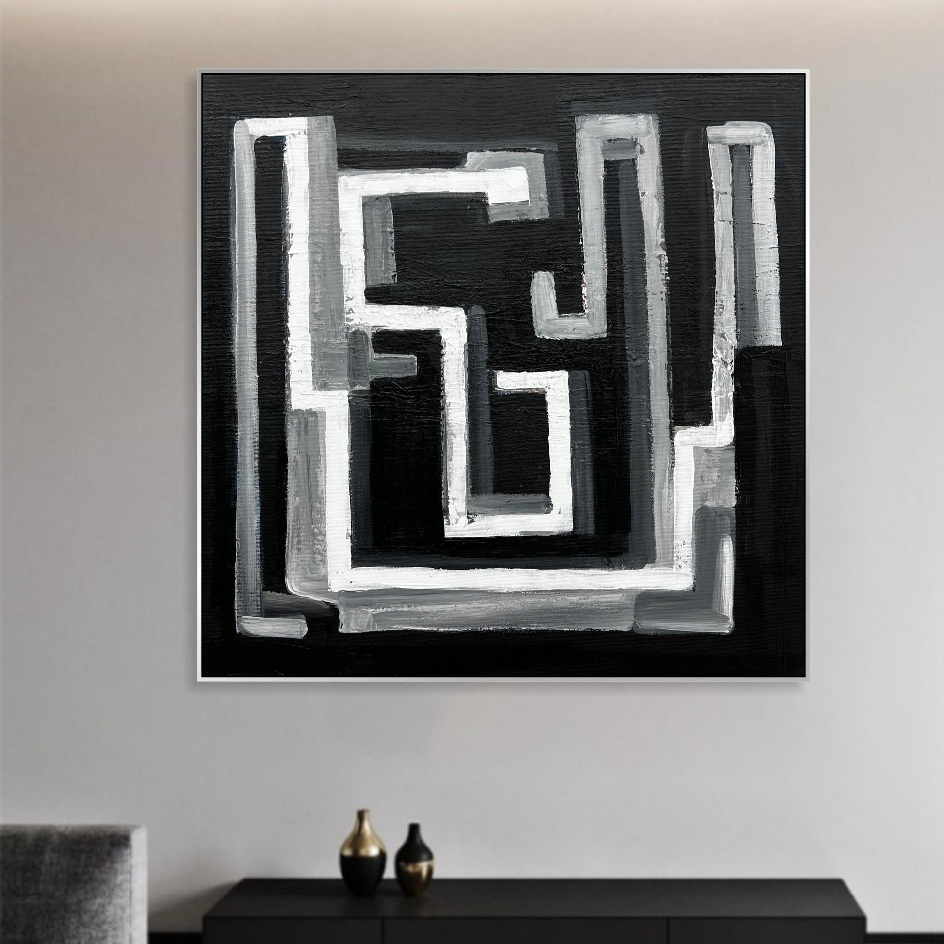 a black and white painting hanging on a wall