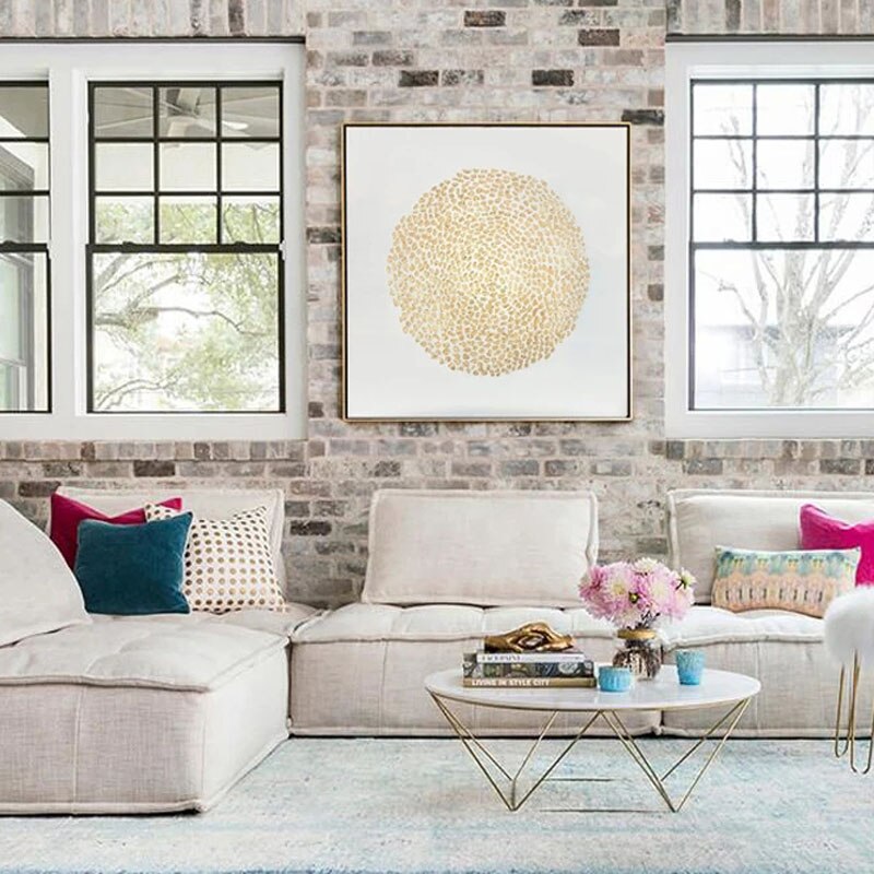 a living room filled with furniture and a brick wall