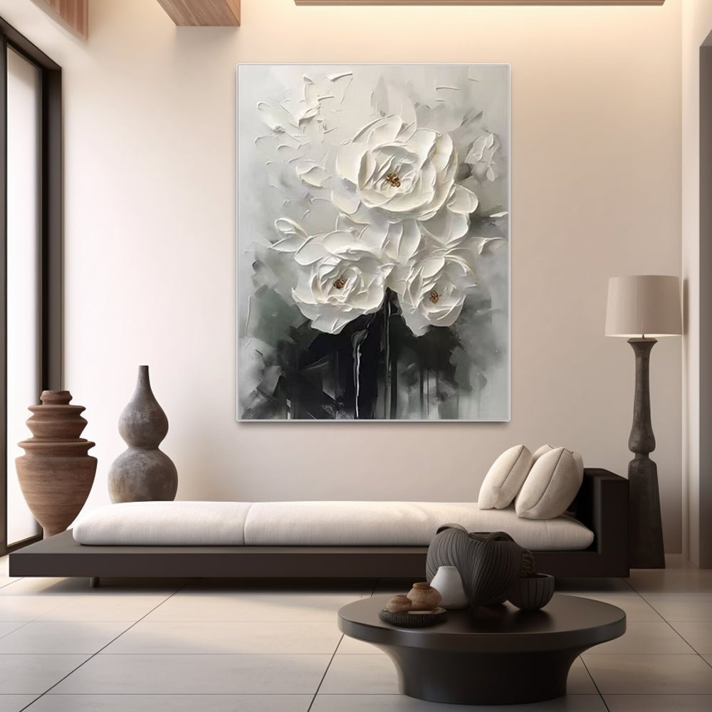 a modern living room with a large, abstract painting of white flowers hanging on the wall above a black sofa.