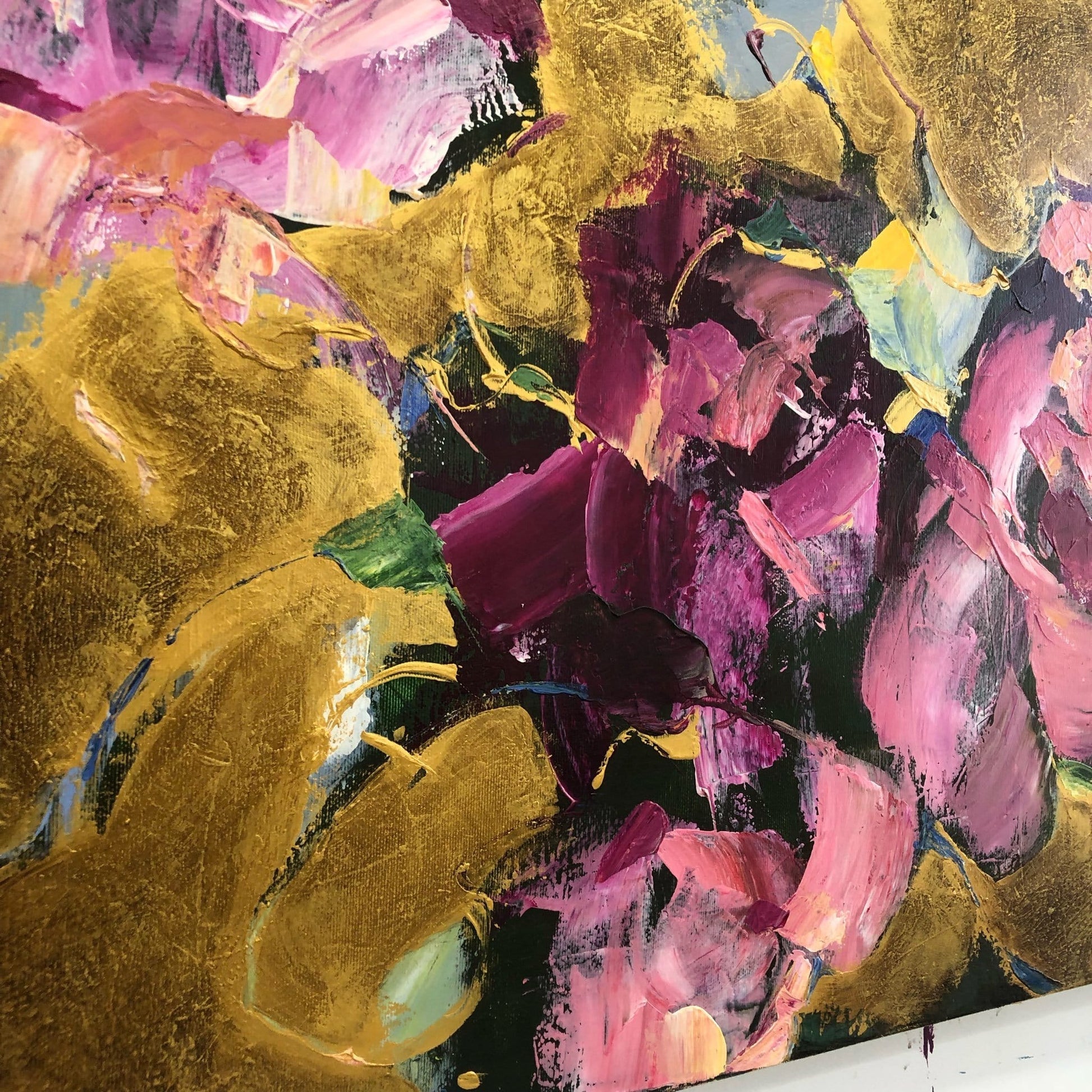 The image is an abstract painting with a vibrant mix of colors, including shades of pink, purple, yellow, and green. The painting appears to be a large canvas with bold brushstrokes and a sense of movement and energy.
