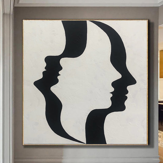 The image is a large abstract painting featuring two black silhouettes of faces facing each other, creating a striking visual contrast against a white background.