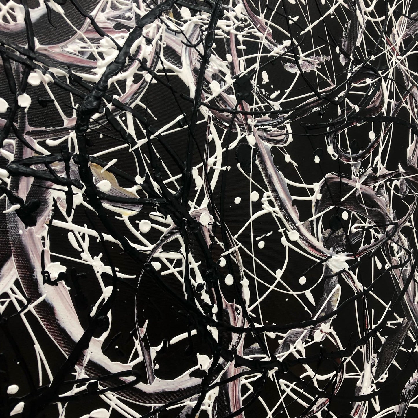 The image is an abstract painting with a black and white color scheme, featuring a chaotic and intricate pattern of lines, shapes, and splatters.