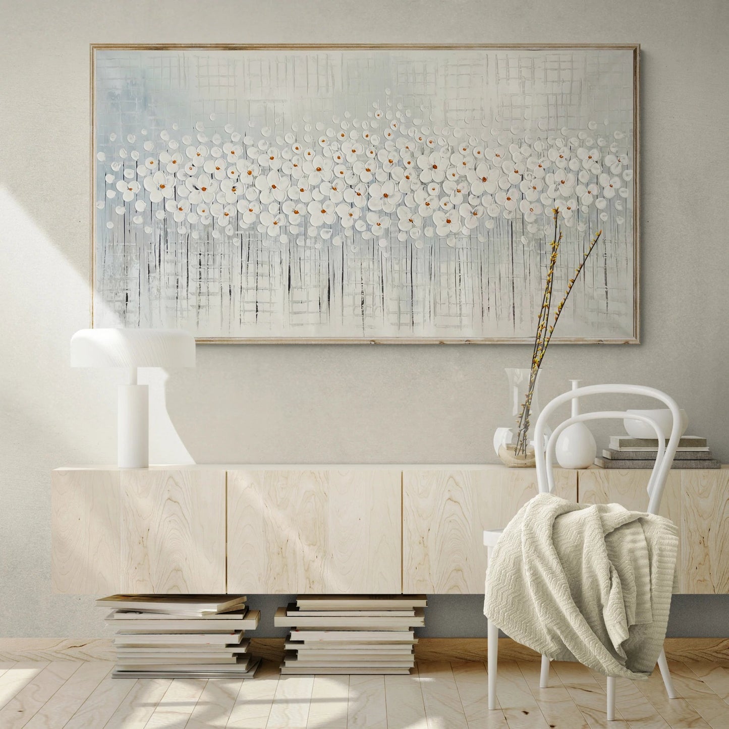 a white chair sitting in front of a painting on a wall