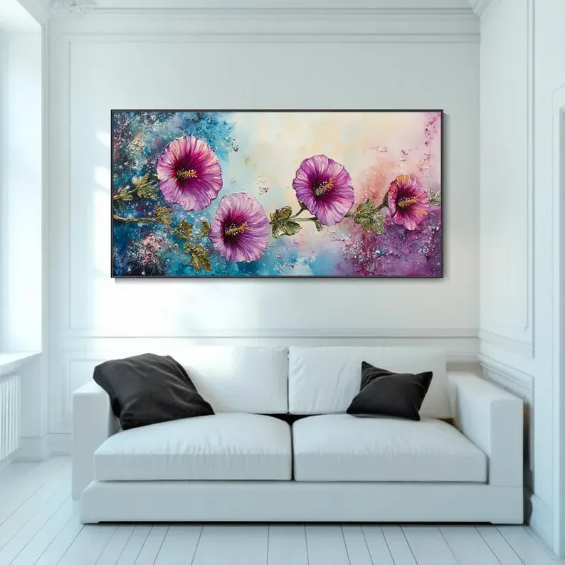 A large, colorful painting of flowers adorns the wall above a white sofa in a bright, airy room.