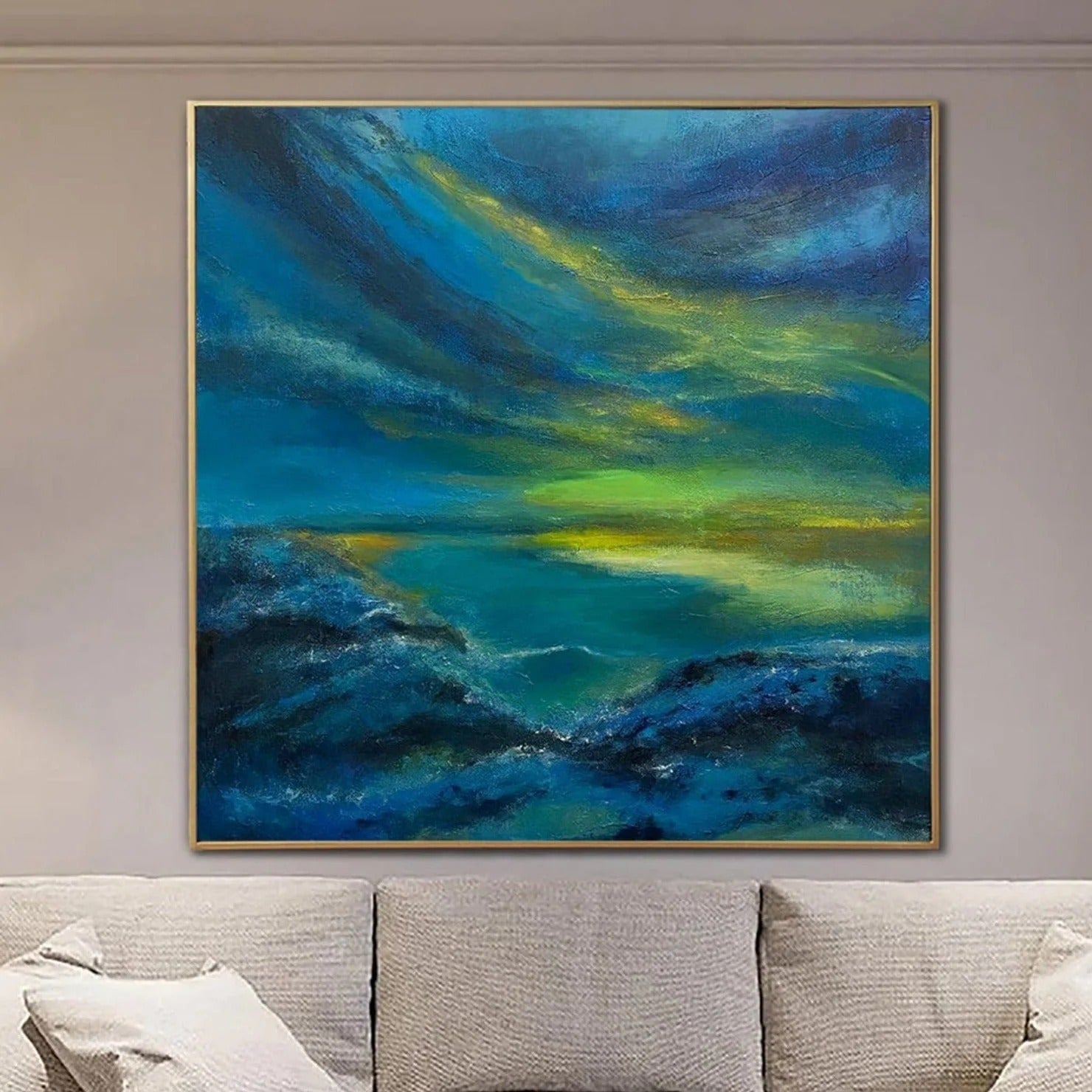 a large, vibrant painting hanging on a wall above a couch. The painting depicts a serene landscape with a body of water and a sky filled with clouds in shades of blue and green.