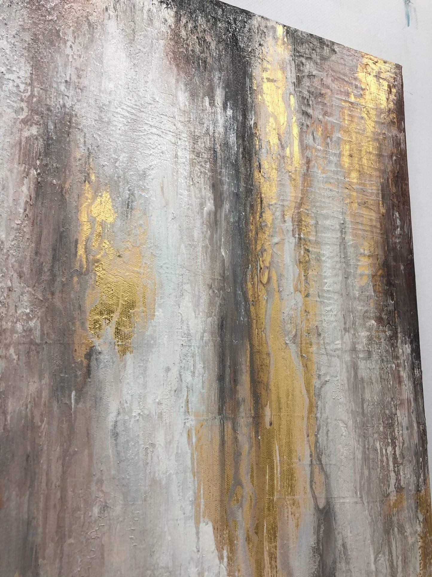 a painting with gold and silver paint on a white wall