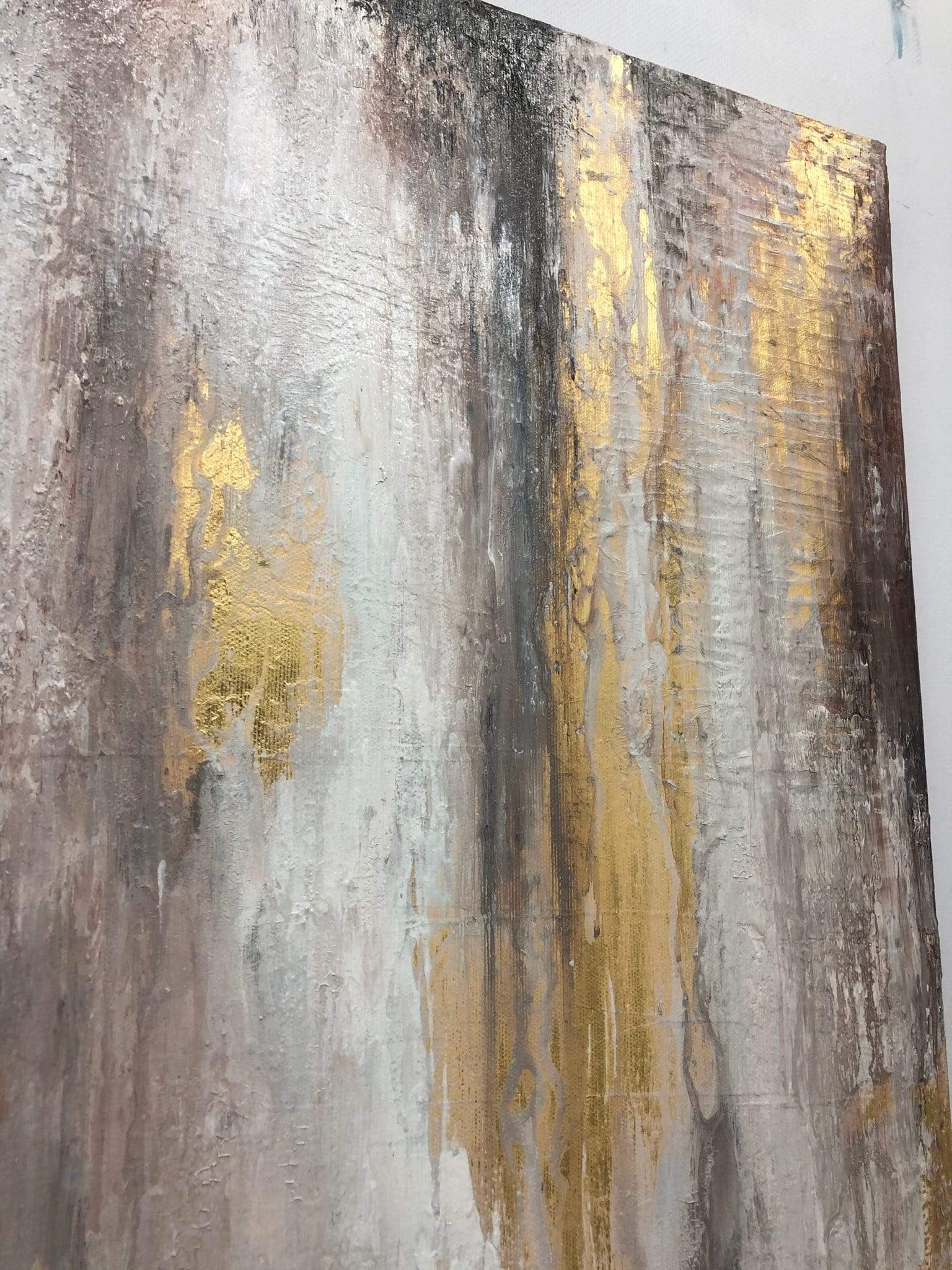 a painting with gold and silver paint on a white wall