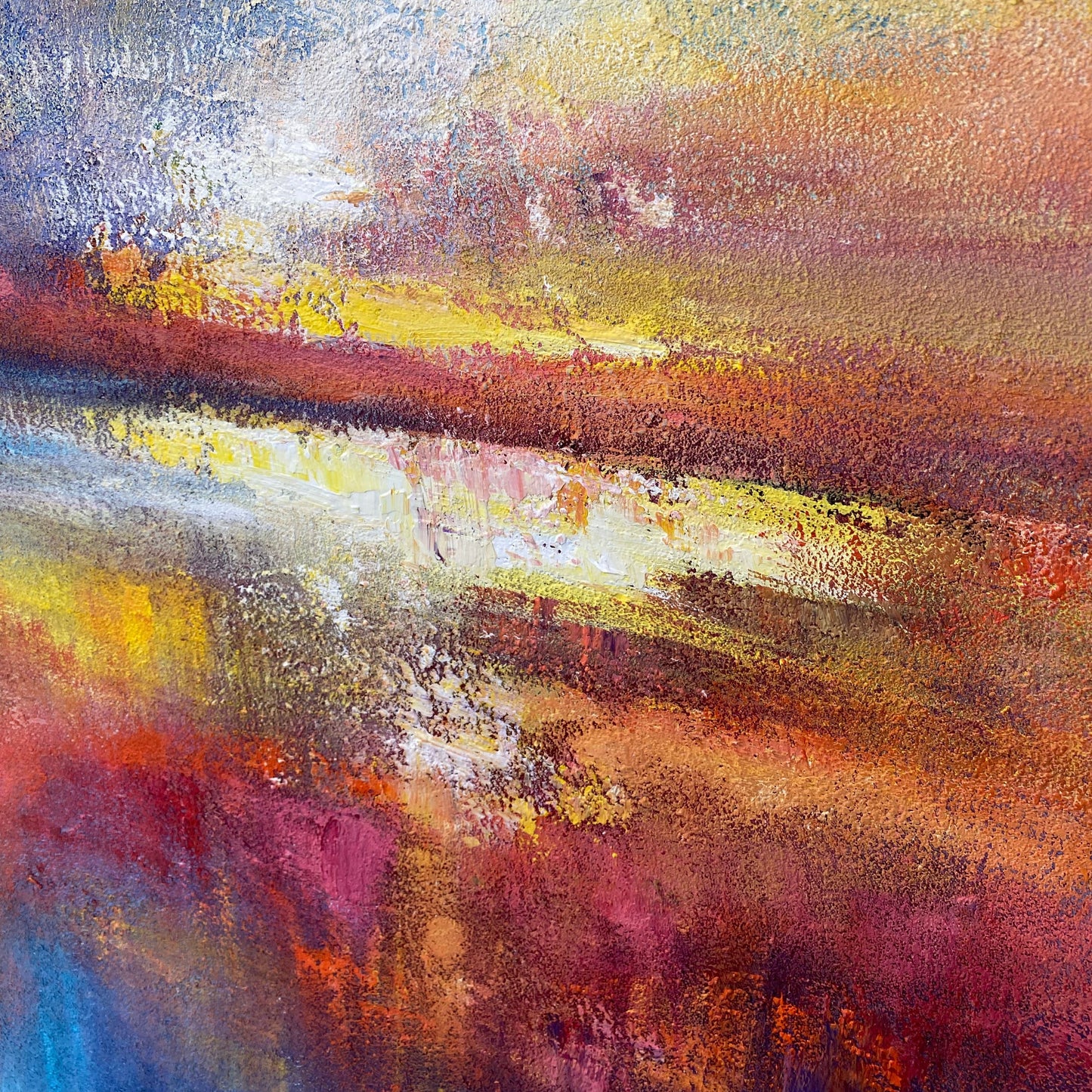 The image is an abstract painting with a vibrant mix of warm colors, including red, orange, yellow, and pink, creating a dynamic and energetic composition.