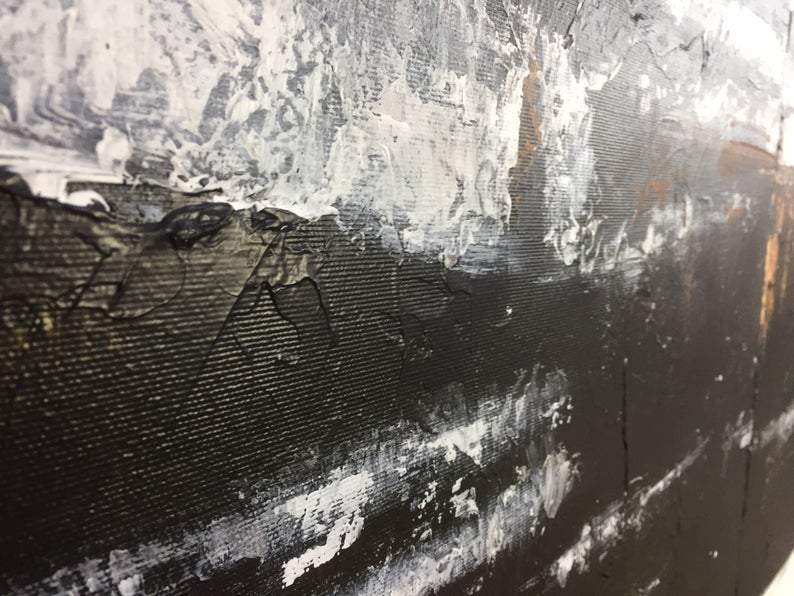 a close up of a black and white painting on a wall