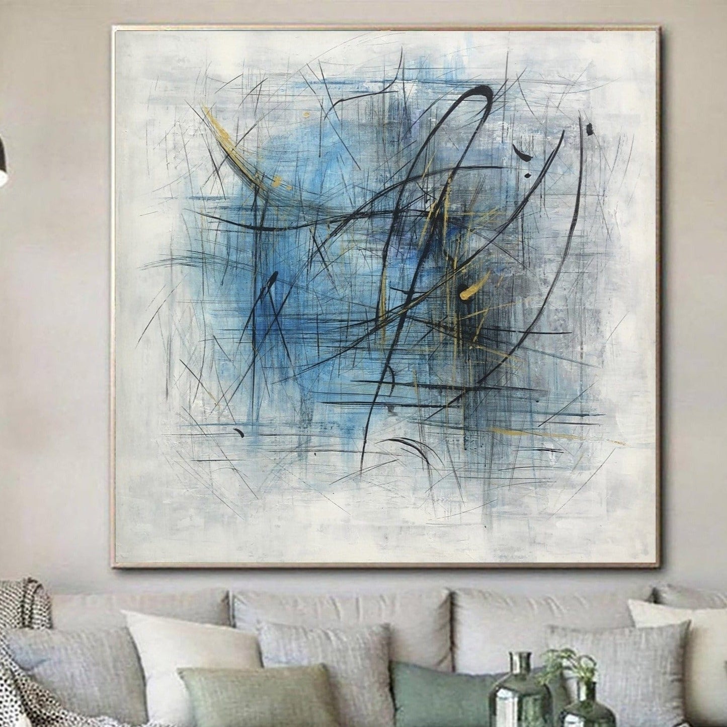 a large abstract painting hanging on a wall above a couch with pillows.