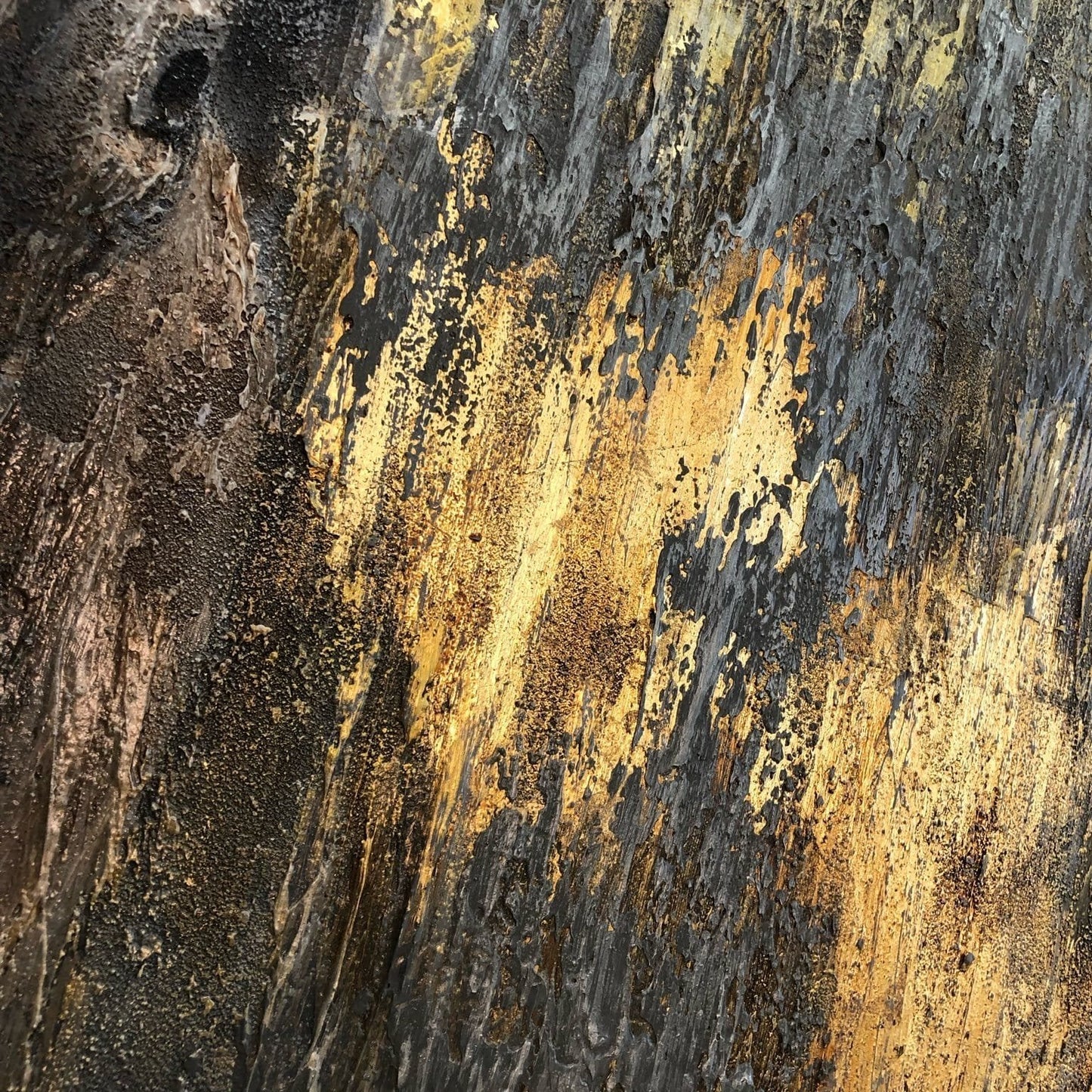The image is a close-up of a textured surface with a mix of dark and light colors, including shades of black, yellow, and brown. The surface appears to be a wooden or metal material, with a rough, textured appearance.