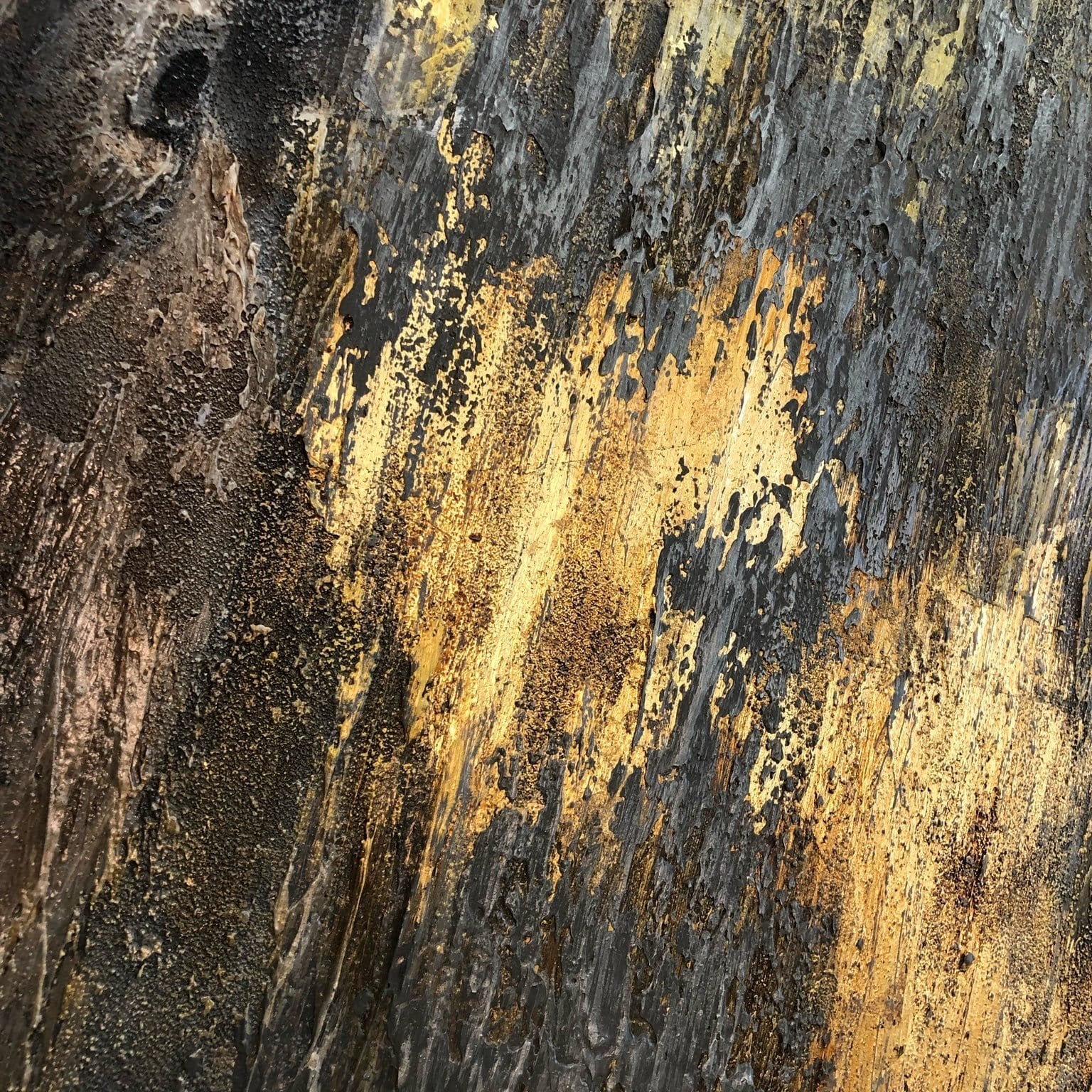 The image is a close-up of a textured surface with a mix of dark and light colors, including shades of black, yellow, and brown. The surface appears to be a wooden or metal material, with a rough, textured appearance.