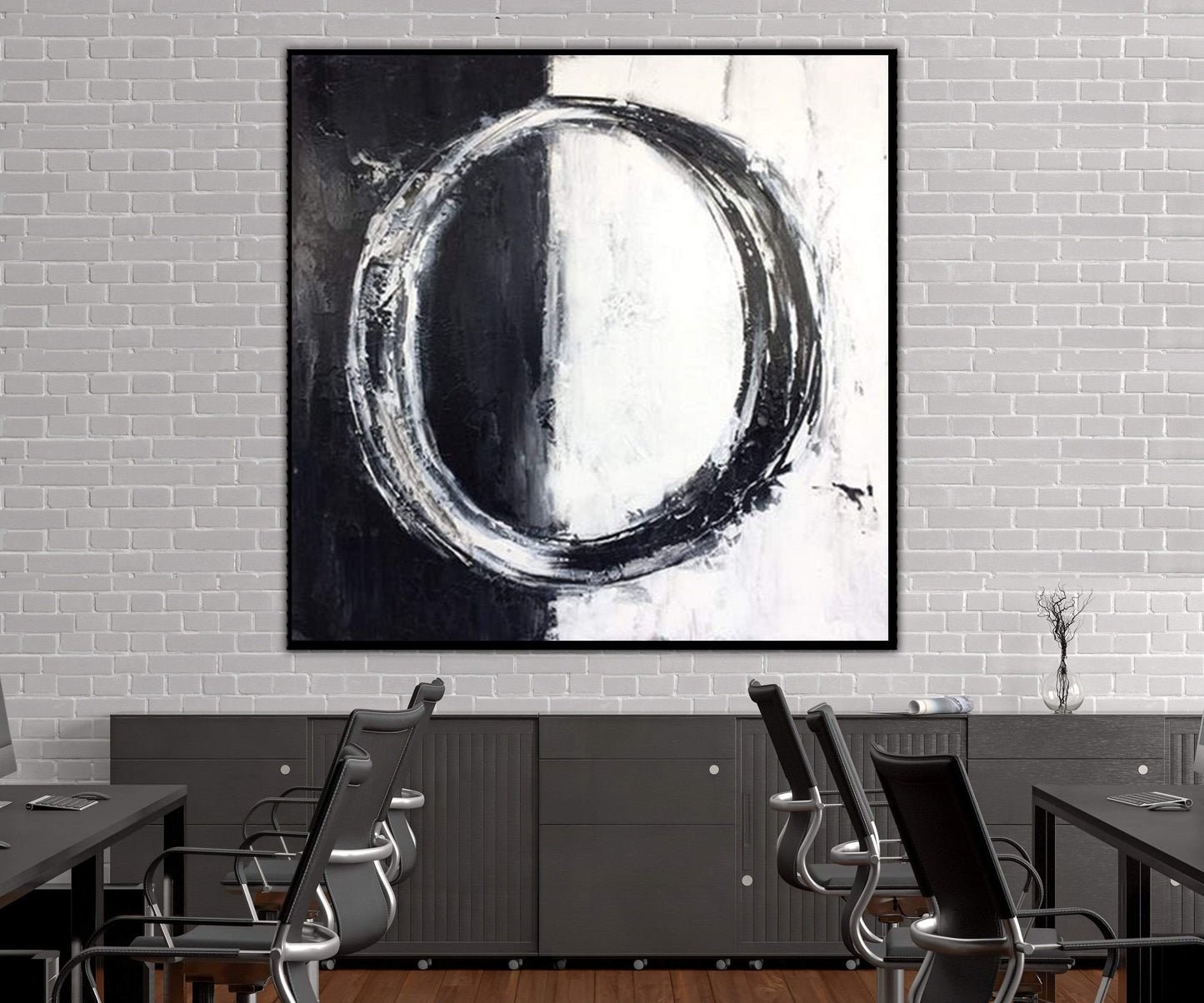 a black and white painting hanging on a white brick wall