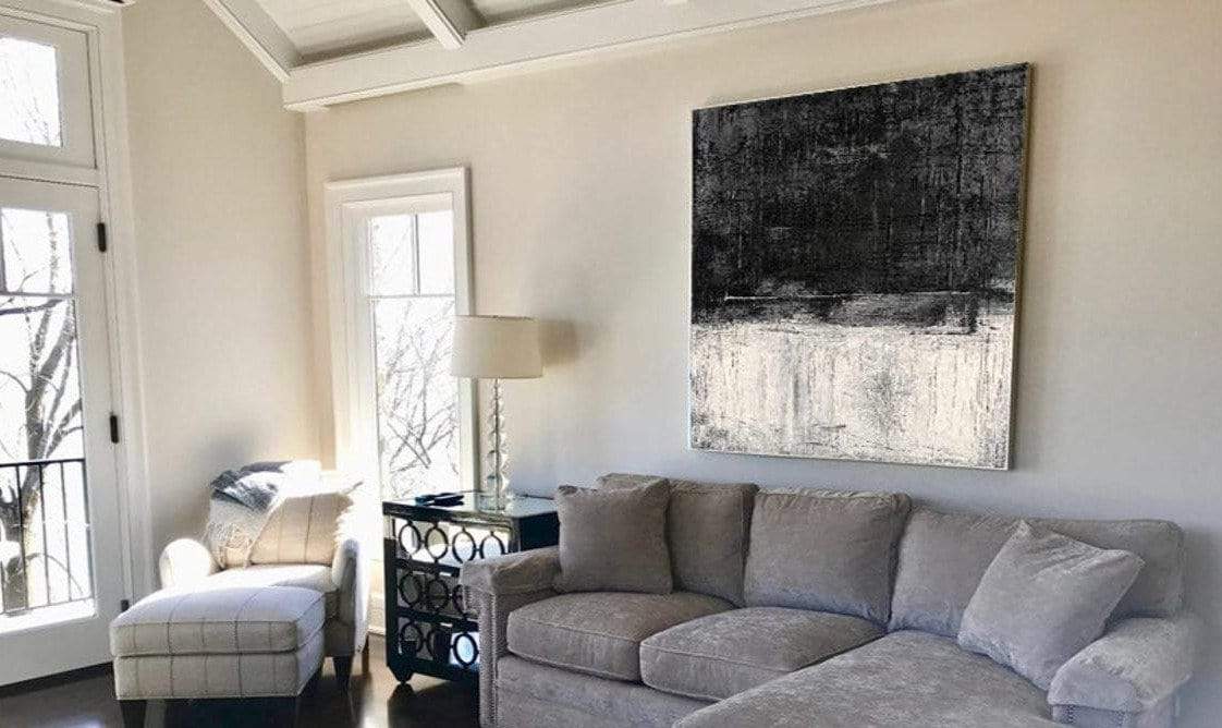 a living room filled with furniture and a painting on the wall