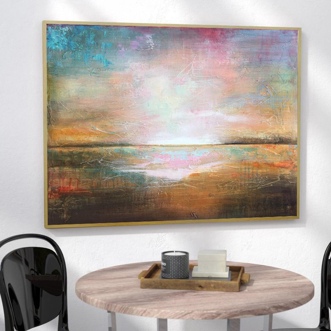 a large abstract painting hanging on a white wall above a wooden table with a black tray on it.