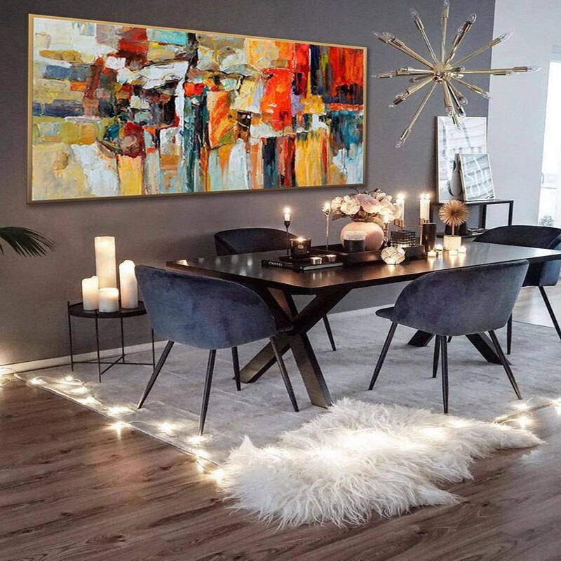 a modern dining room with a large painting on the wall