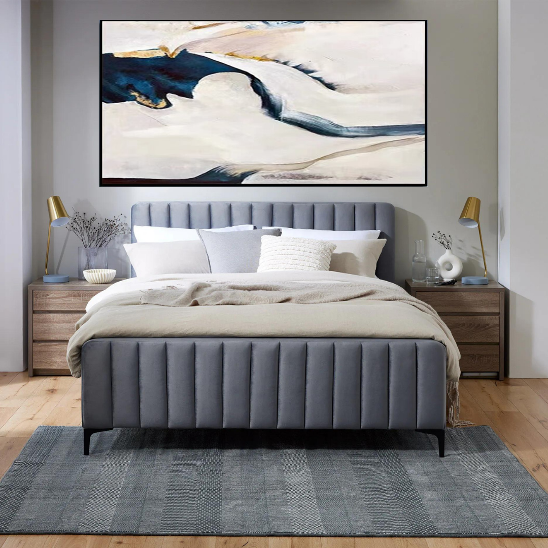 a bedroom with a large painting above the bed