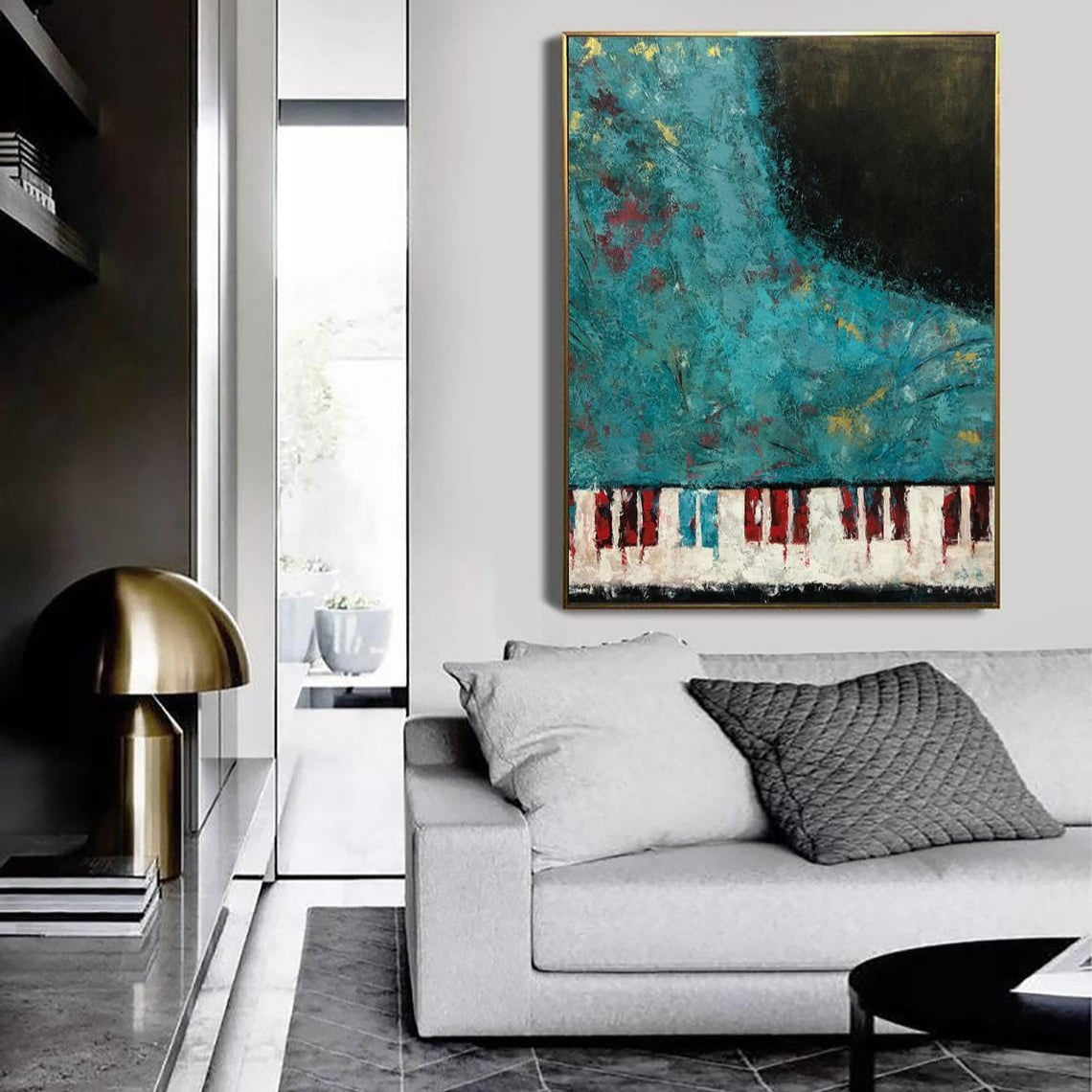 a modern living room with a large abstract painting hanging on the wall above a white sofa. The painting has a vibrant blue and green color scheme with red and white accents. The room has a sleek black and white color scheme, with a black coffee table and a gold lamp on a side table.