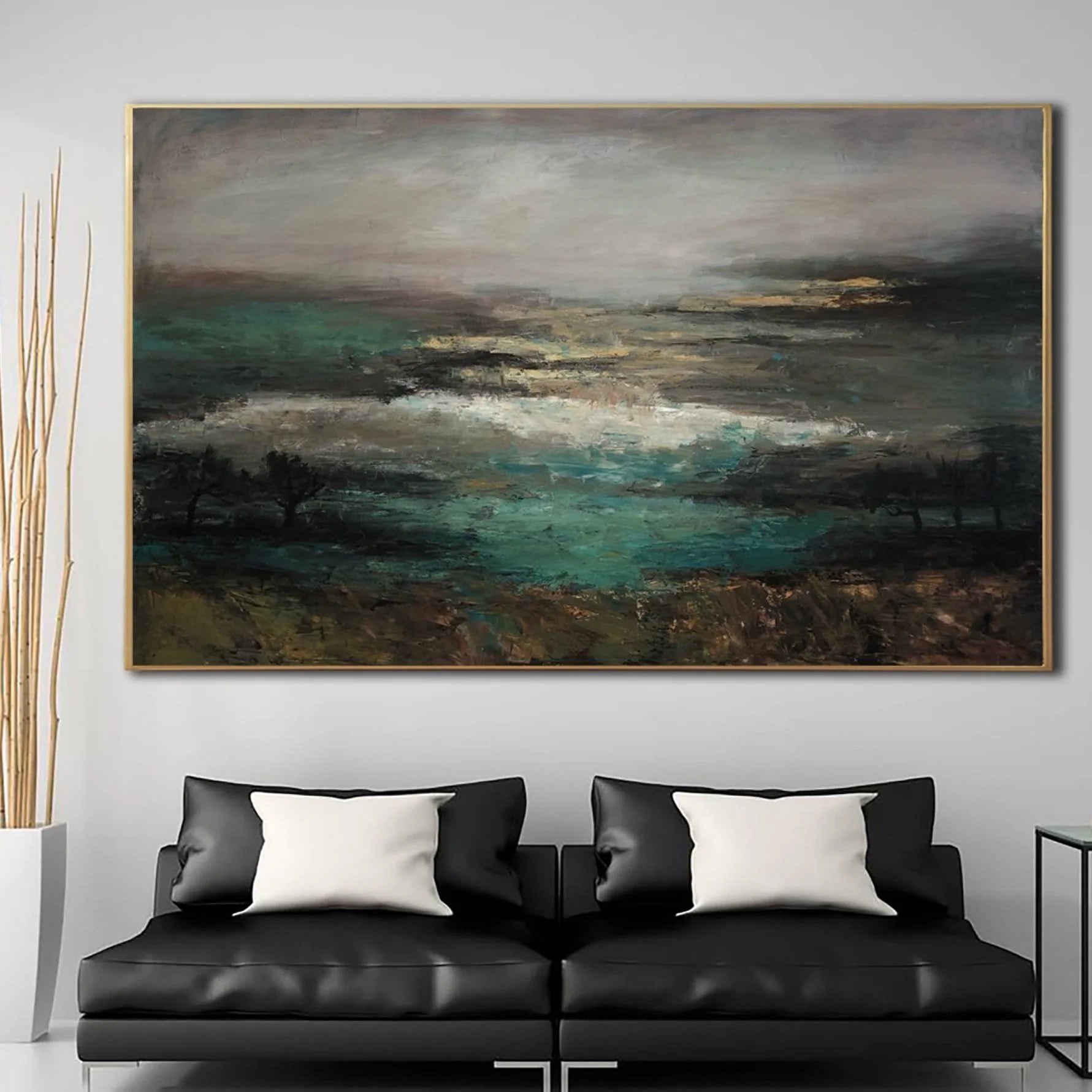 a large, abstract landscape painting hanging on a wall above a black leather sofa with white throw pillows.