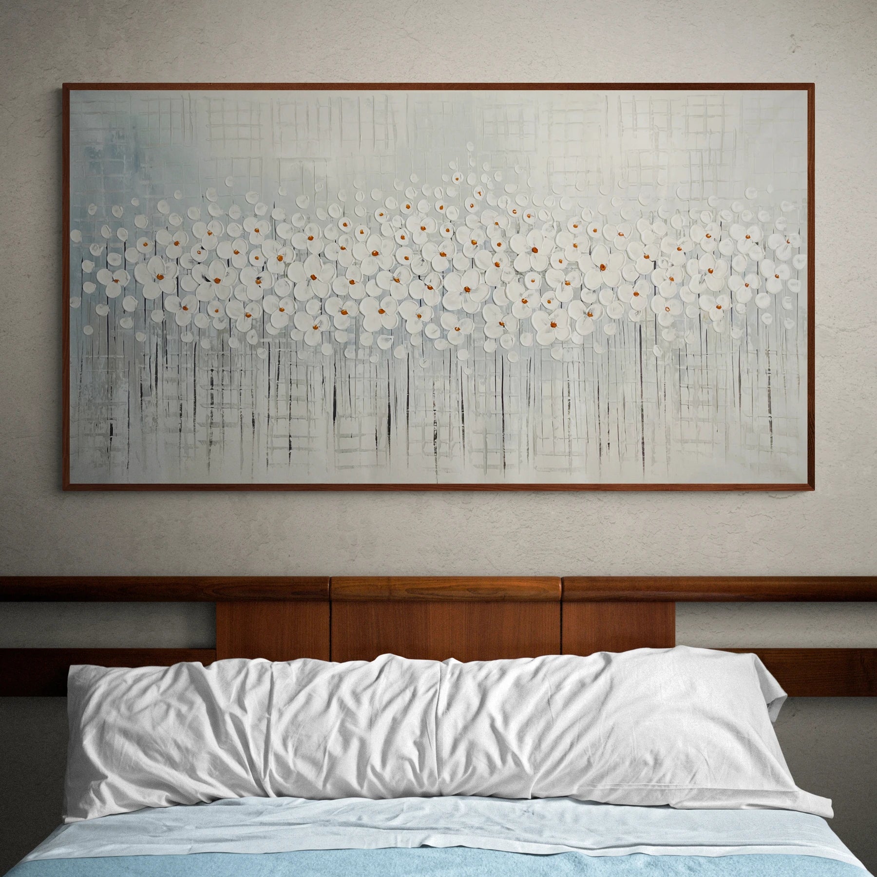 a painting hanging above a bed in a bedroom