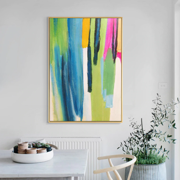 a painting hanging on a wall above a table