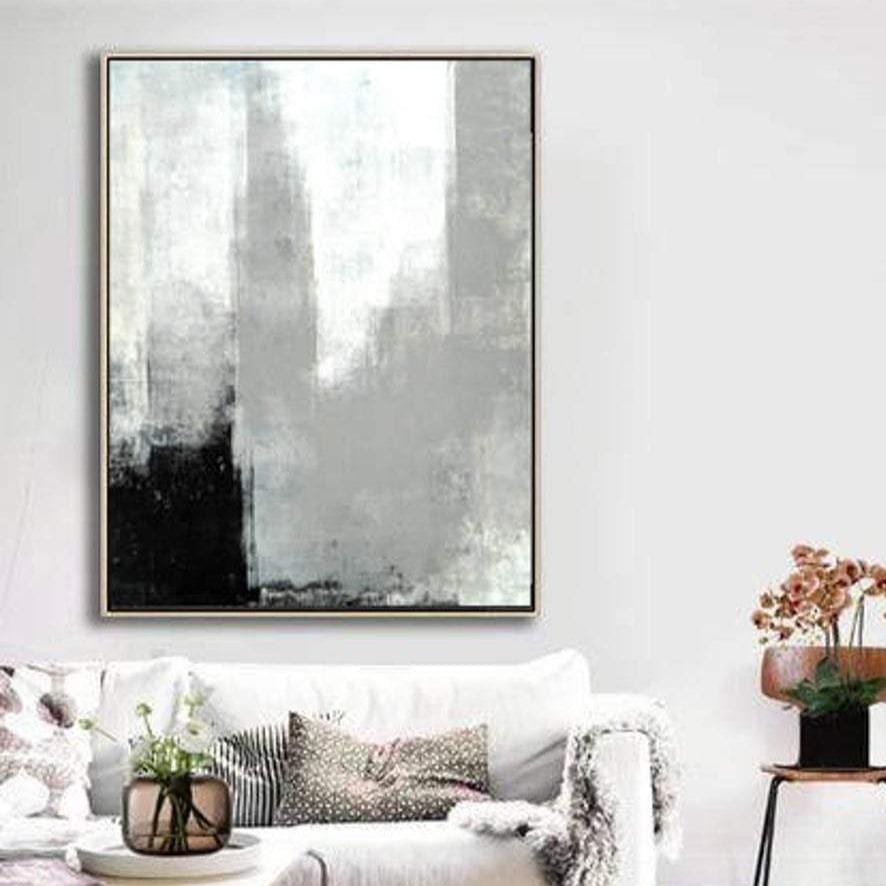 a large abstract painting hanging on a white wall above a white couch with decorative pillows.