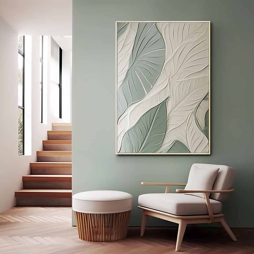 a modern living room with a large abstract painting of green and white leaves hanging on the wall, a wooden staircase, and a white armchair.