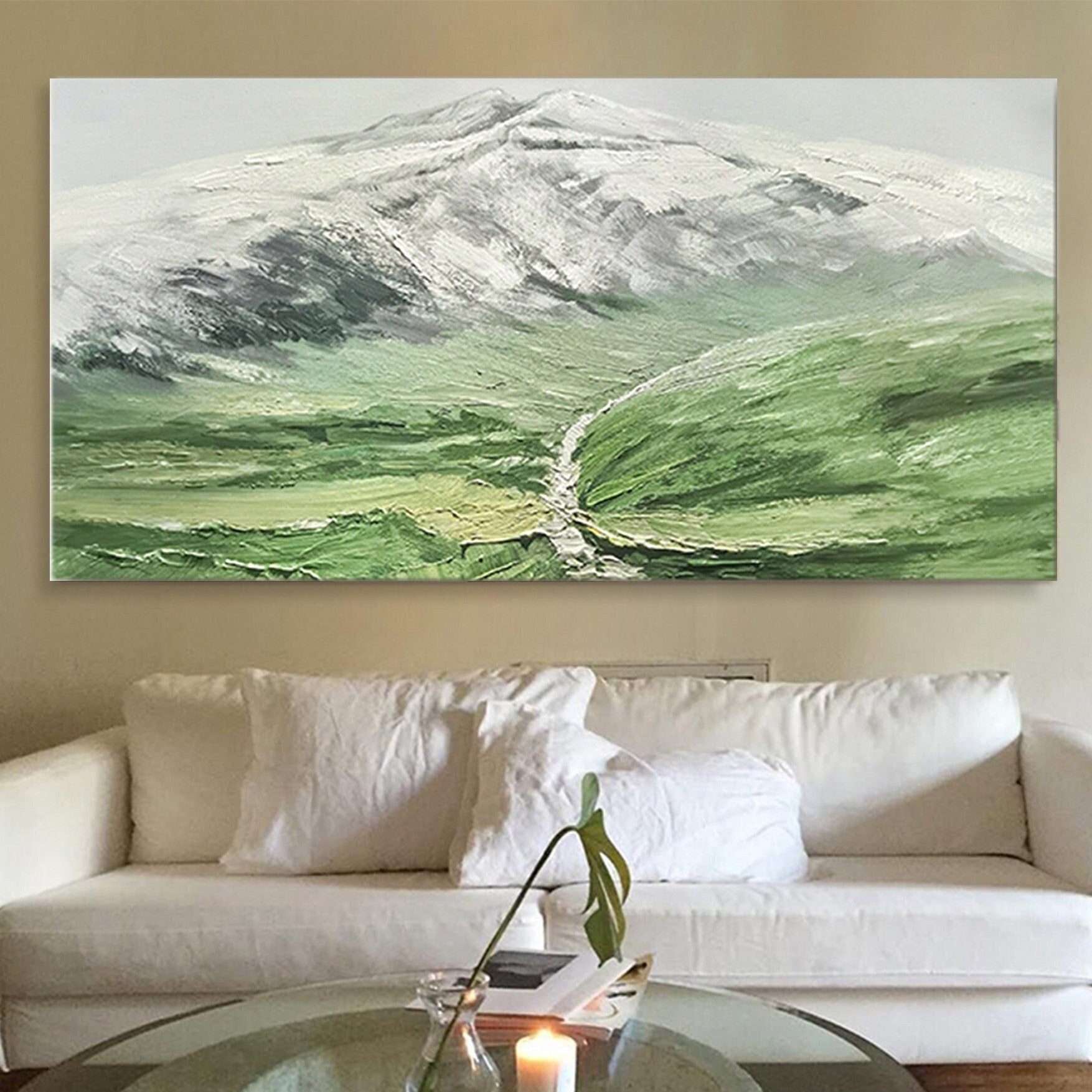 a living room with a white couch and a painting on the wall