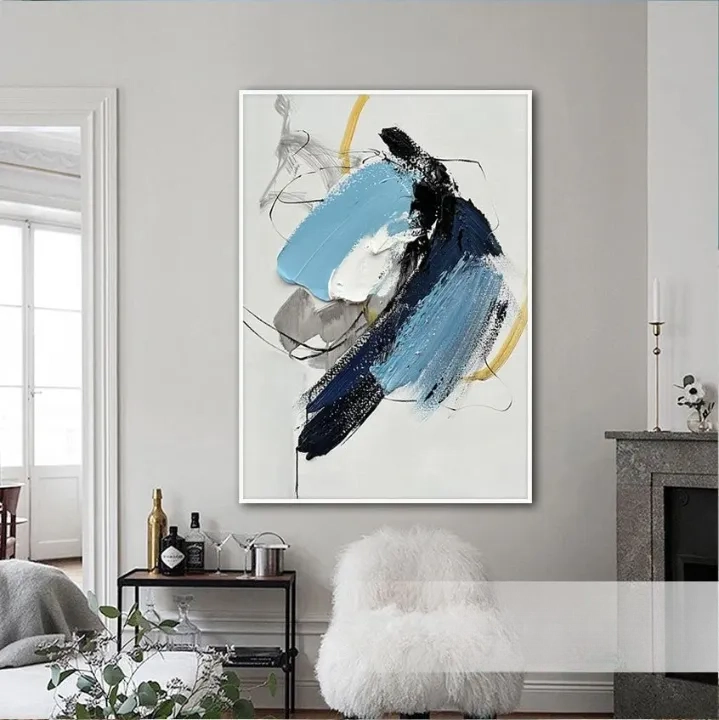 a large abstract painting hanging on a wall in a living room. The painting has a mix of blue, black, and white colors, creating a dynamic and visually striking composition.