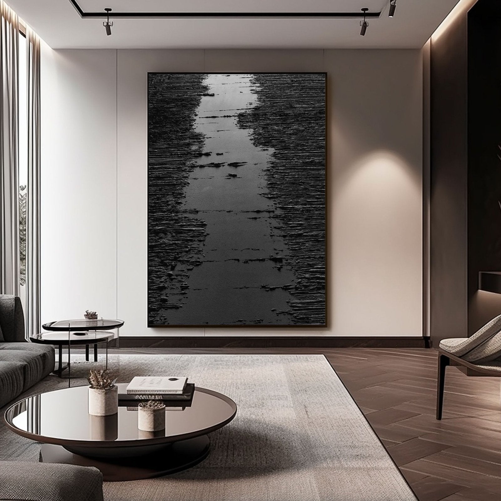 a modern living room with a large black and white abstract painting on the wall, a glass coffee table in the center, and a gray sofa and armchair.