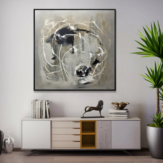 a modern living room with a large abstract painting hanging on the wall above a white cabinet with drawers. The cabinet has a decorative metal horse figurine on top. The room also includes a potted plant and some books, creating a stylish and contemporary atmosphere.